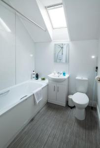a bathroom with a white tub and a toilet and a sink at Taigh Carnan - 2 Huntly Terrace in Inverness