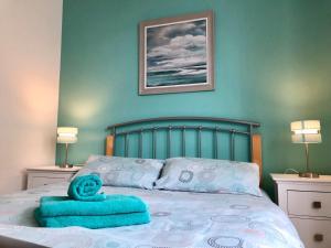 a bed with a blue towel on top of it at Portrush Holiday Hostel Guesthouse in Portrush