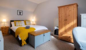 ein Schlafzimmer mit einem Bett mit einer gelben Decke darauf in der Unterkunft Taigh Carnan - 2 Huntly Terrace in Inverness