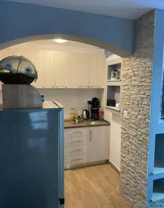 a kitchen with a refrigerator and a stone wall at Tina's holiday house in Vela Luka