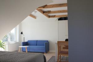 1 dormitorio con sofá azul y silla en Bed and Breakfast i Gelsted, en Gelsted