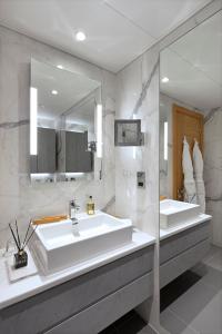 baño con 2 lavabos y espejo grande en Tower Residences by Blue Orchid en Londres