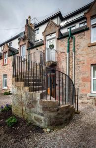 a brick house with a staircase in front of it at Taigh Carnan - 2 Huntly Terrace in Inverness