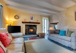 a living room with two couches and a fireplace at The Corn Mill in Solva