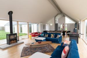 a living room with a blue couch and a fireplace at A Stunning State Of The Art Eco Home - Games Room in Westhill 
