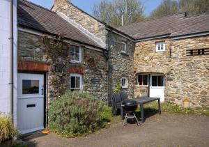 a stone house with a grill in front of it at The Corn Mill in Solva