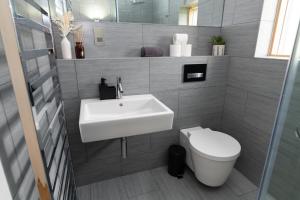 a bathroom with a sink and a toilet at A Stunning State Of The Art Eco Home - Games Room in Westhill  +93 photos