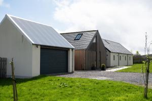a group of three barns with a garage at A Stunning State Of The Art Eco Home - Games Room in Westhill 
