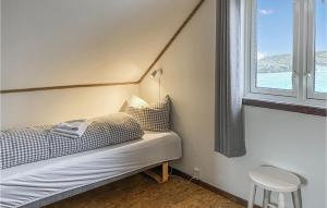 małe łóżko w pokoju z oknem w obiekcie Beautiful Home In Offersy With Kitchen w mieście Offersøy