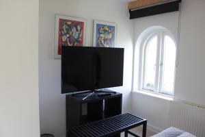 a flat screen tv sitting on a black stand in a room at Bed and Breakfast i Gelsted in Gelsted