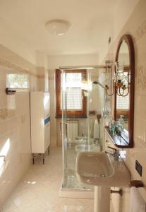 uma casa de banho com um lavatório e uma cabina de duche em vidro. em la casa di mario em Massa