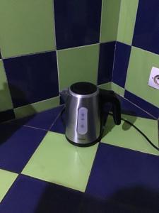a coffee pot sitting on a tiled floor at Résidence Keur Fleurie in Toubab Dialaw