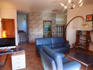 uma sala de estar com um sofá de couro azul e uma televisão em la casa di mario em Massa