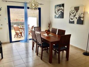 Un comedor con mesa y sillas de madera. en Villa Pura Vida, en Playa Blanca