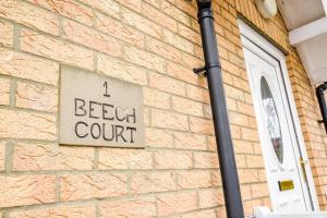 ein Schild an der Seite eines Backsteingebäudes in der Unterkunft Beech Court House By Horizon Stays in Widdrington