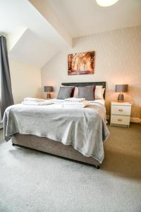 a bedroom with a large bed with two lamps at Beech Court House By Horizon Stays in Widdrington
