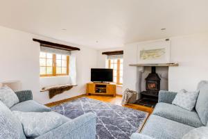 un soggiorno con due divani e un camino di Dingles Cottage a Saint Minver