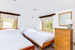 due letti in una stanza con due finestre di Dingles Cottage a Saint Minver