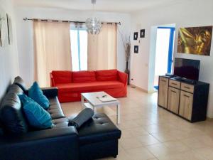 sala de estar con sofá y sofá rojo en Villa Pura Vida, en Playa Blanca