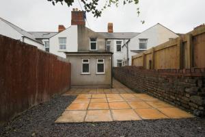 a house with a retaining wall and a brick sidewalk at A Perfect 3BD Home away from Home Canton Cardiff in Cardiff