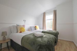 een slaapkamer met 2 bedden en een raam bij A Perfect 3BD Home away from Home Canton Cardiff in Cardiff