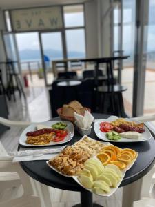 una mesa con tres platos de comida. en The Blue Horizon, en Vlorë