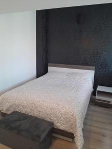 a bedroom with a bed and a ottoman at Apartament Królewiecka 54b/26 in Mrągowo