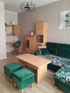 a living room with a green couch and a table at Apartament Królewiecka 54b/26 in Mrągowo