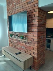 a brick wall with a tv on top of it at Apartament Królewiecka 54b/26 in Mrągowo