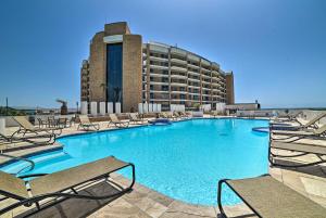 a large swimming pool with chairs and a hotel at Port Aransas Vacation Rental with Pools - Near Beach in Port Aransas