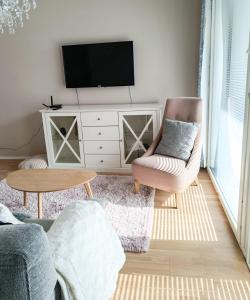 salon z telewizorem i krzesłem w obiekcie North Path Apartments w mieście Rovaniemi