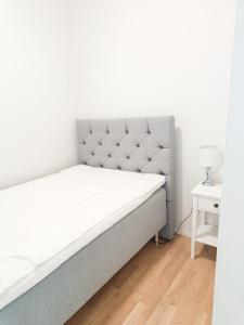 1 cama en un dormitorio con una pared blanca en North Path Apartments, en Rovaniemi