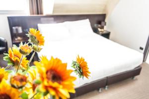 een bed met een bos zonnebloemen in een kamer bij Hotel Mosaico & Residence in Ravenna