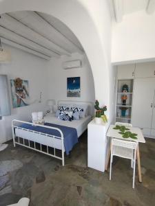 een witte slaapkamer met een bed en een tafel bij Scarpathia Studio in Katápola