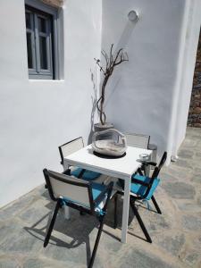 een witte tafel met twee stoelen en een vaas erop bij Scarpathia Studio in Katápola
