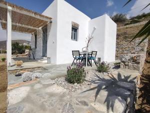 a white house with a table and chairs in front of it at Scarpathia House in Katapola