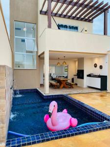 a swimming pool with a pink swan in a house at Casa Flecheiras 52 in Flecheiras
