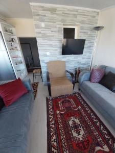 - un salon avec un canapé et une télévision dans l'établissement Arko sitesi, à Karaburun