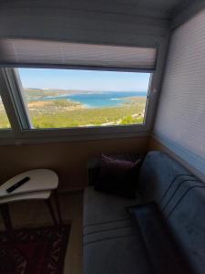 een woonkamer met een bank en een groot raam bij Arko sitesi in Karaburun