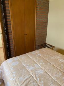1 dormitorio con 1 cama y armario de madera en Departamentos Ailen en Esquel