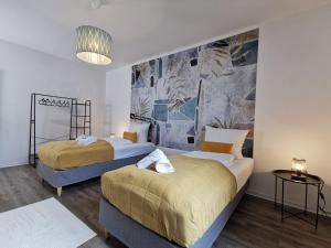 1 Schlafzimmer mit 2 Betten und Wandgemälde in der Unterkunft BohnApartments - Town House am Stadtpark - gratis Parkplatz - WLAN in Erfurt