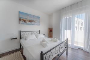 a white bedroom with a bed with white sheets and pillows at Apartment Glamorous Getaway in Zadar