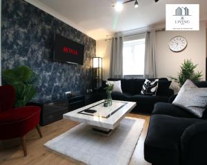 a living room with a couch and a coffee table at Spacious 3 Bedroom Duplex Apartment On Cardiff Bay - Free Parking & WIFI By EKLIVING LUXE Short Lets & Serviced Accommodation in Cardiff