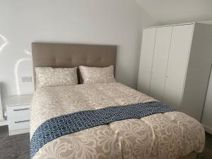 Eaglet luxury home في مانشستر: غرفة نوم بسرير كبير وكابينة بيضاء
