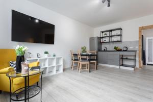 a kitchen and living room with a table and yellow chairs at Vlevo Dole Apartmán 3 in Rokytnice nad Jizerou