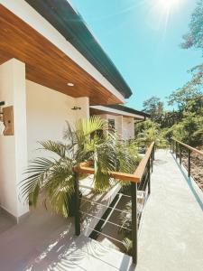 a porch of a house with a bench and a plant at Villa Gaspar Terrazas in Playa hermosa