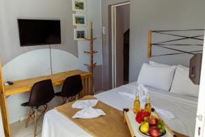 a room with a bed with a tray of fruit on it at VILLAGE 737, 01 QUARTO, piscina, wifi 300mb, 100m da PRAIA in Aracaju +98 photos