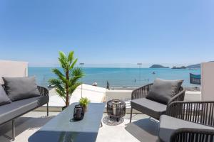 a patio with chairs and a table and the ocean at Akrogiali Luxury View in Laganas