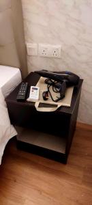 a bedside table with a phone and a remote control at MILAN HOTEL in Johor Bahru