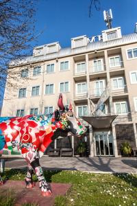 una statua di una mucca di fronte a un edificio di Hotel Mosaico & Residence a Ravenna